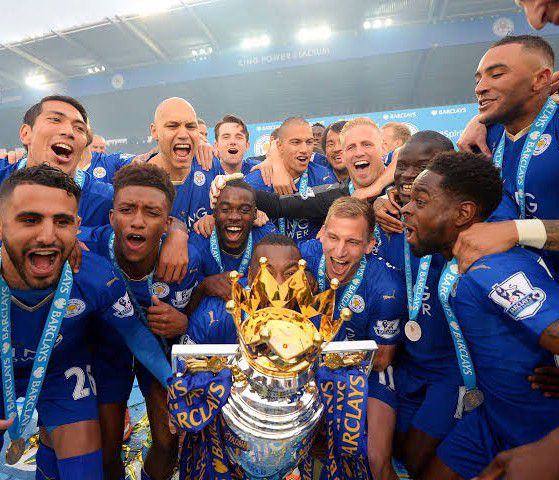 A celebratory team photo featuring stars like Jamie Vardy and Riyad Mahrez.